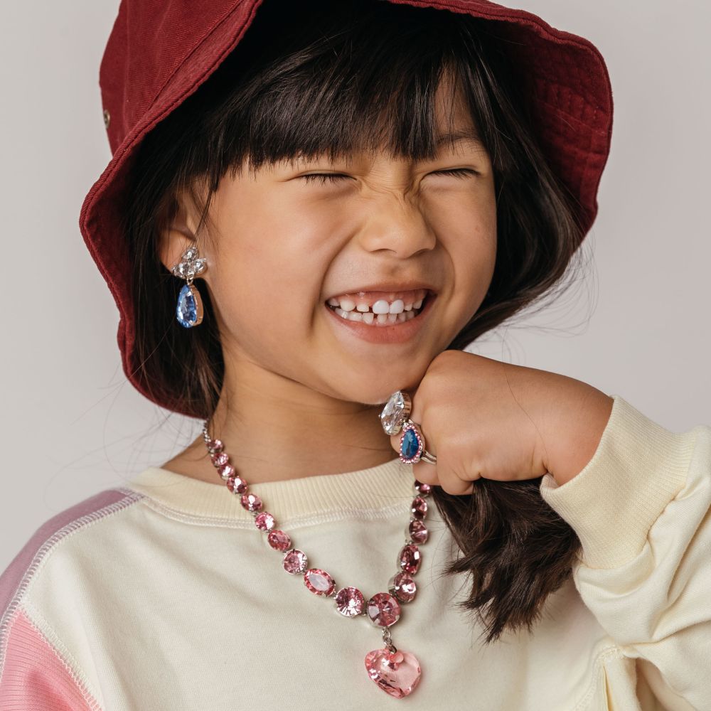 Young girl in a hat wearing earrings, a necklace and rings 