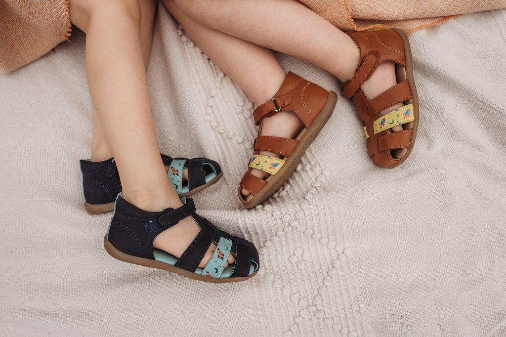 shot of two children's legs wearing sandals by Pip & Henry