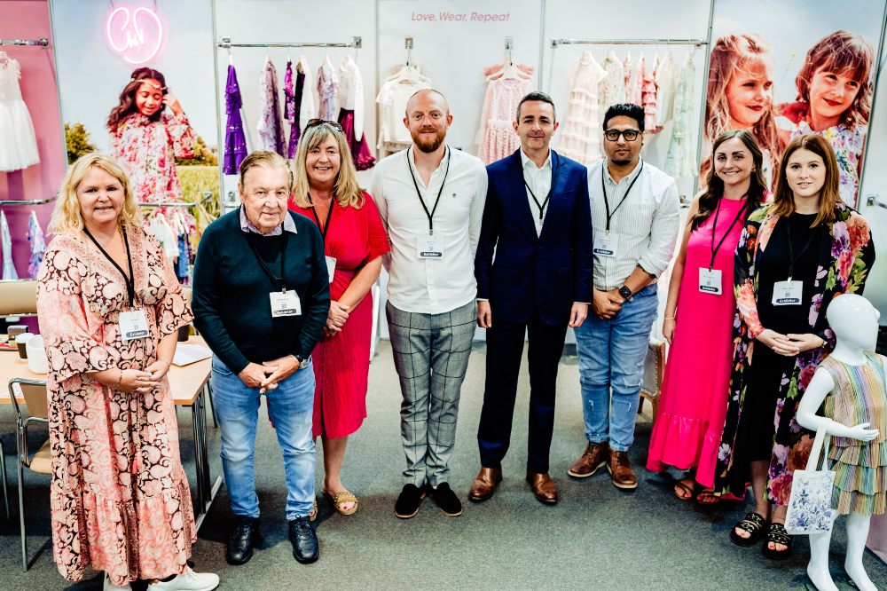 A group of people stood on the GWD kidswear stand at INDX Kids 