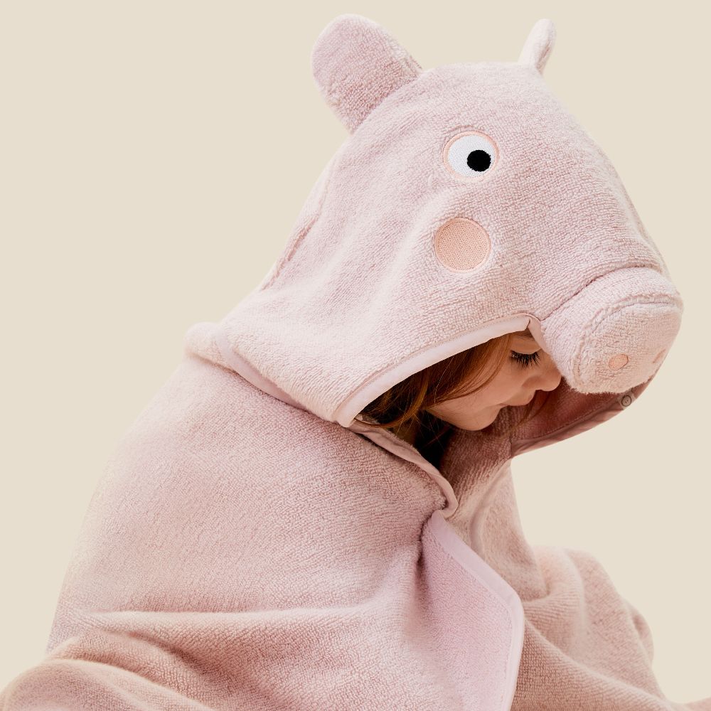 A young child wearing a pink pig hooded towel from the Peppa Pig by Mori collection