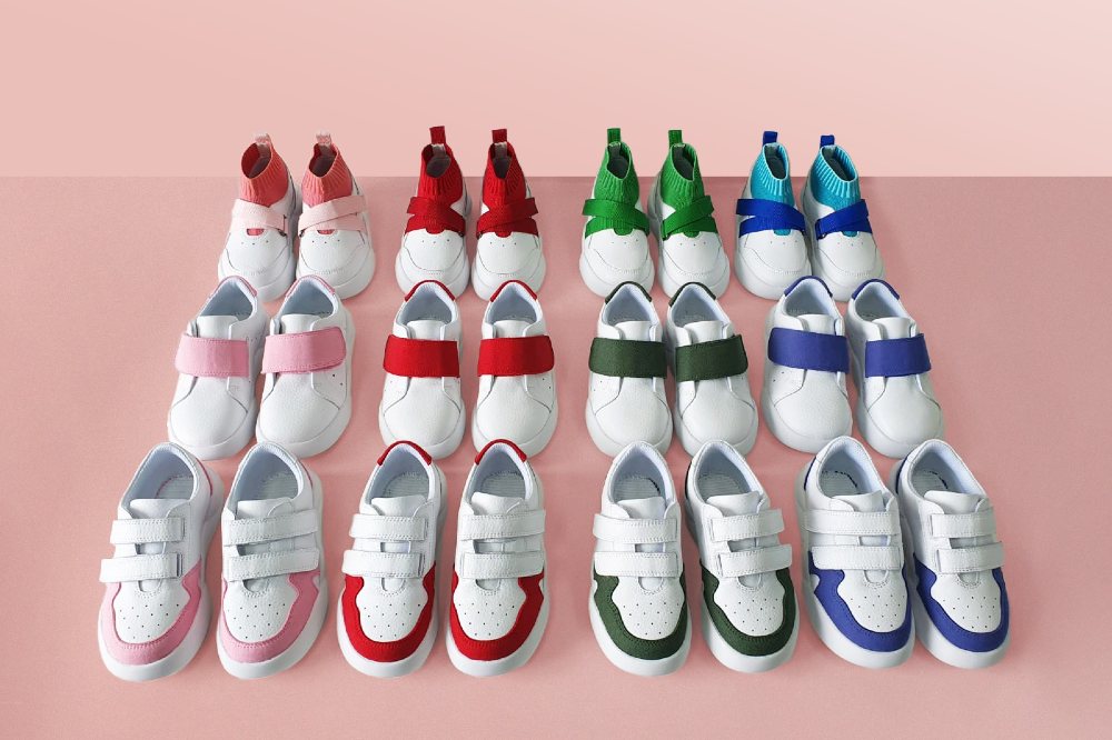 Rows of children's trainers on a pink background