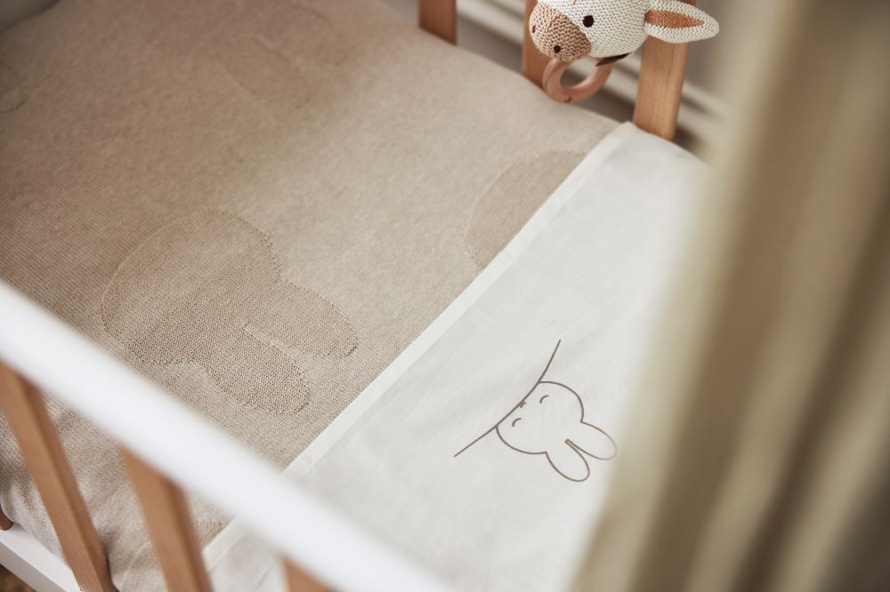 A baby's cot dressed in bedding from the Jollein x Miffy collection