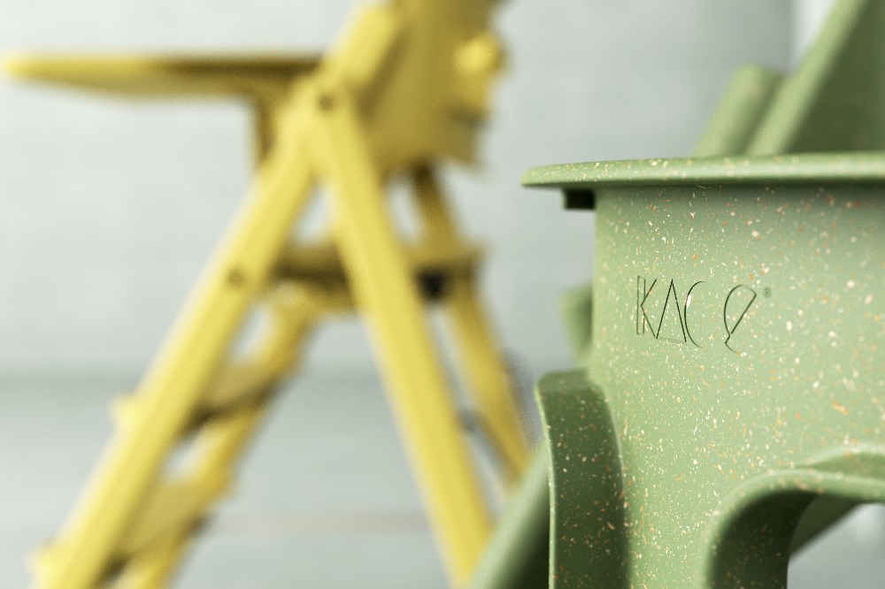 A close up of a yellow and green Klapp highchair by KAOS 