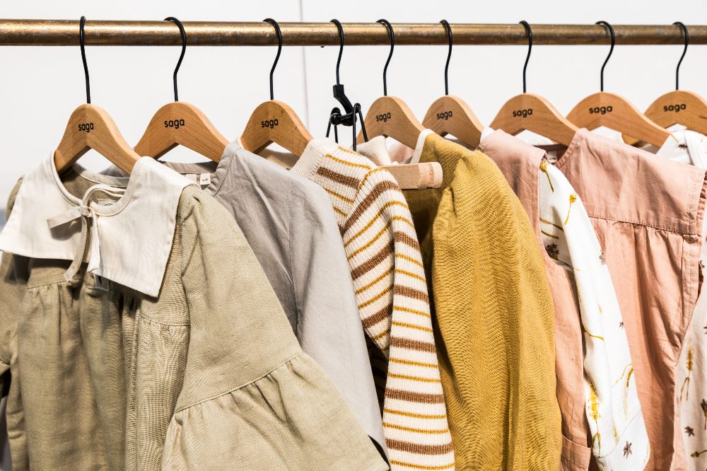 Children's clothes hung on a wooden rail 