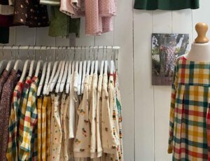 Interior of the Mya Rose childrenswear store showing children's clothes hung on a rail on the wall