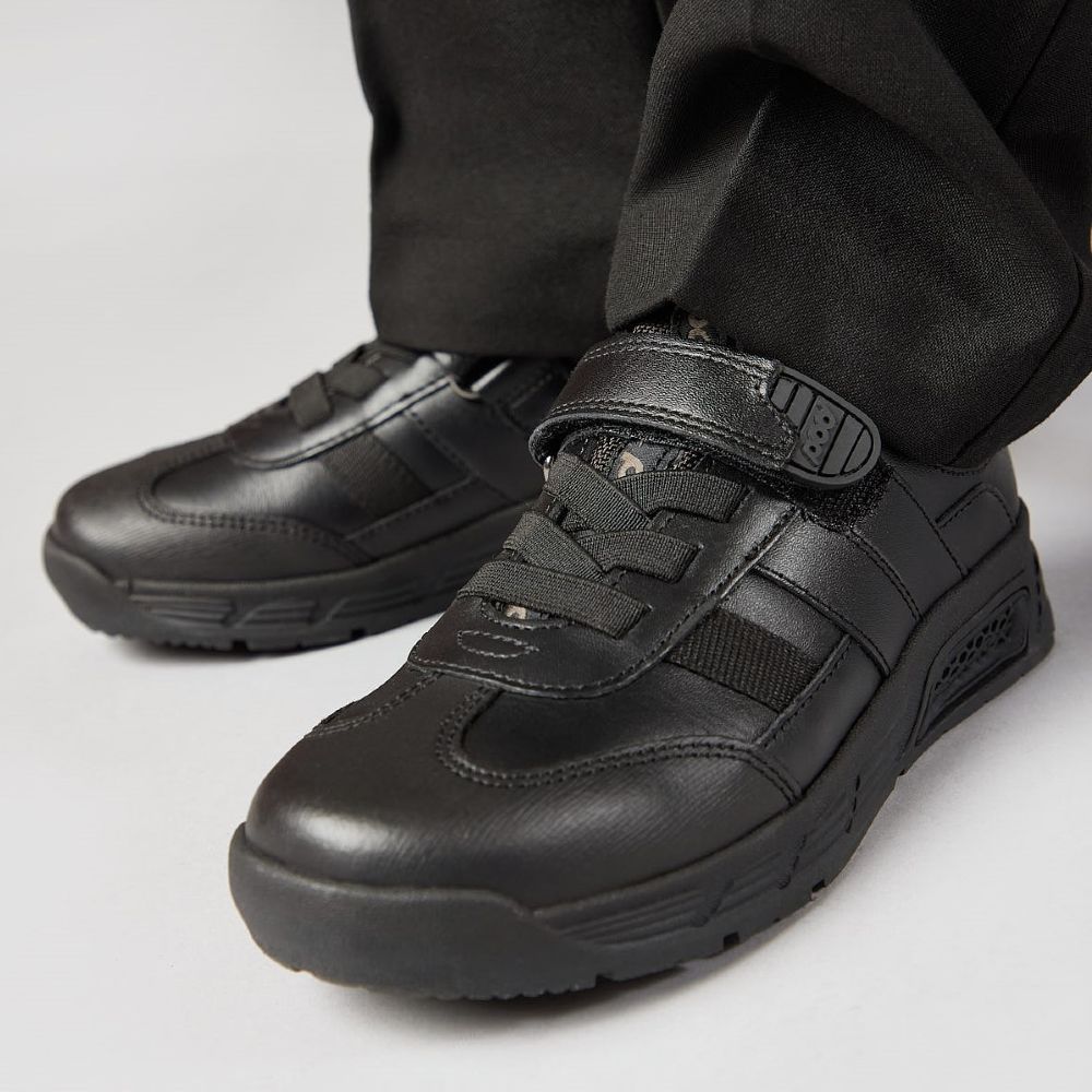 A child's feet wearing black Back to School shoes 