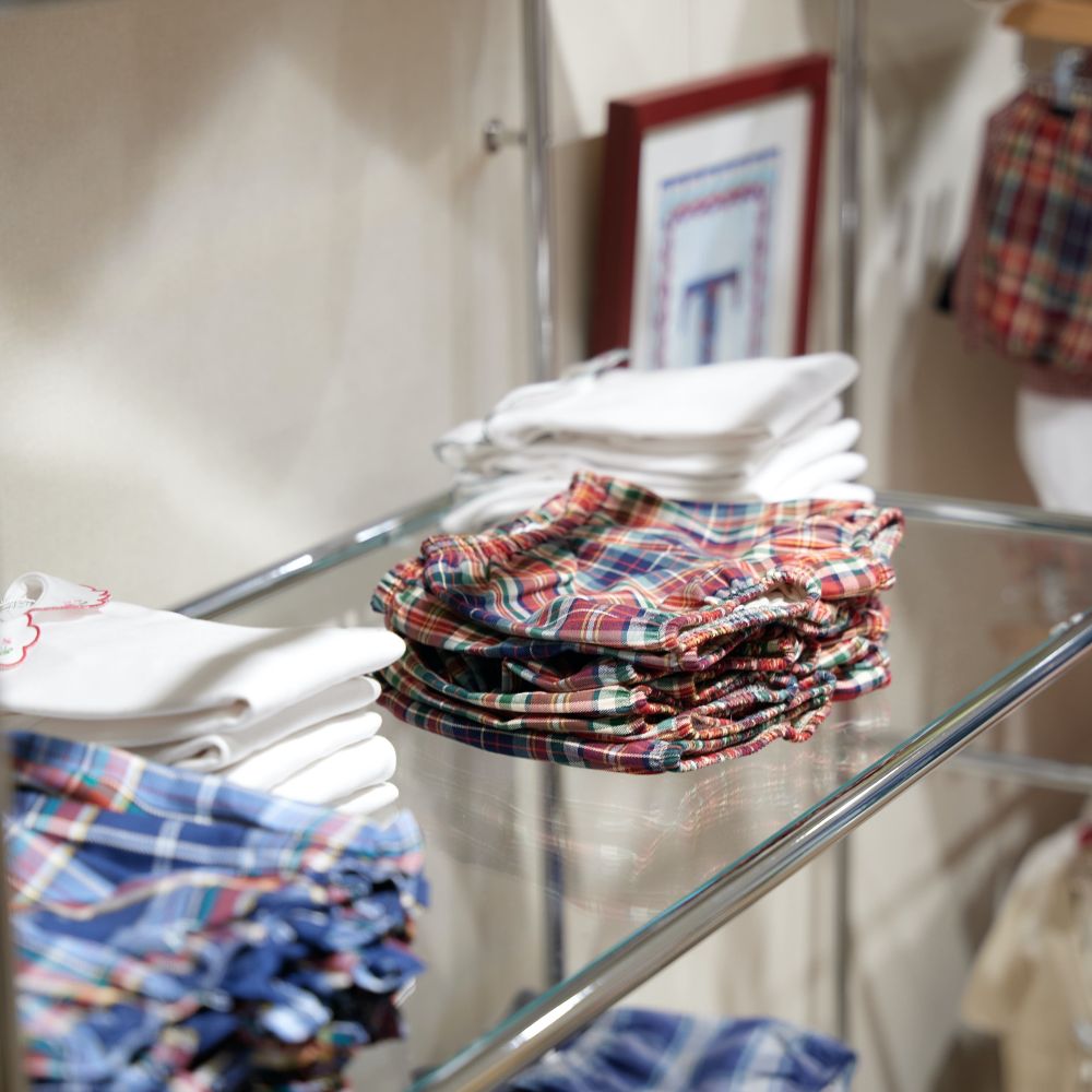 Glass shelves displaying children's folded clothes in the Il Porticciolo childrenswear boutique 