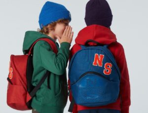 Two children wearing hats and backpacks by North Sails