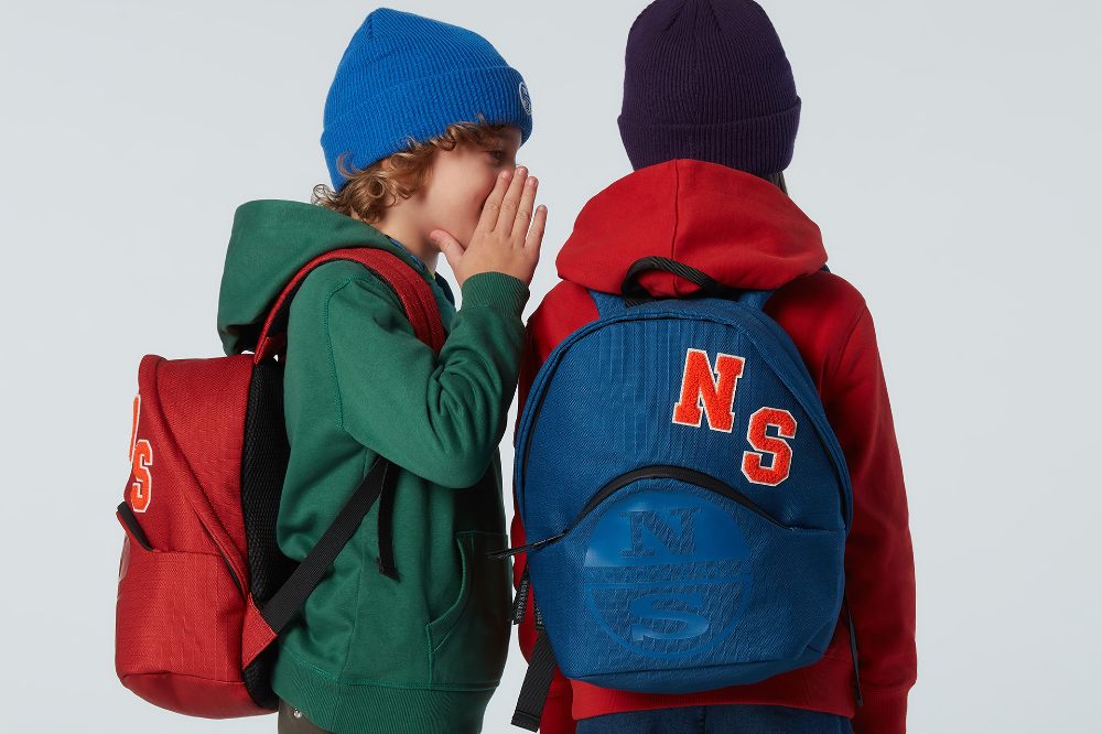 Two children wearing hats and backpacks by North Sails