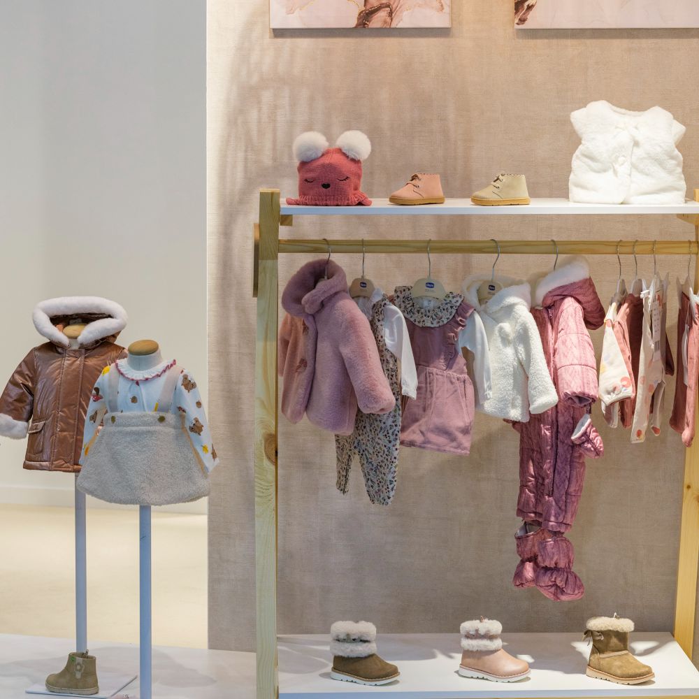 Baby clothes and accessories displayed on a rail