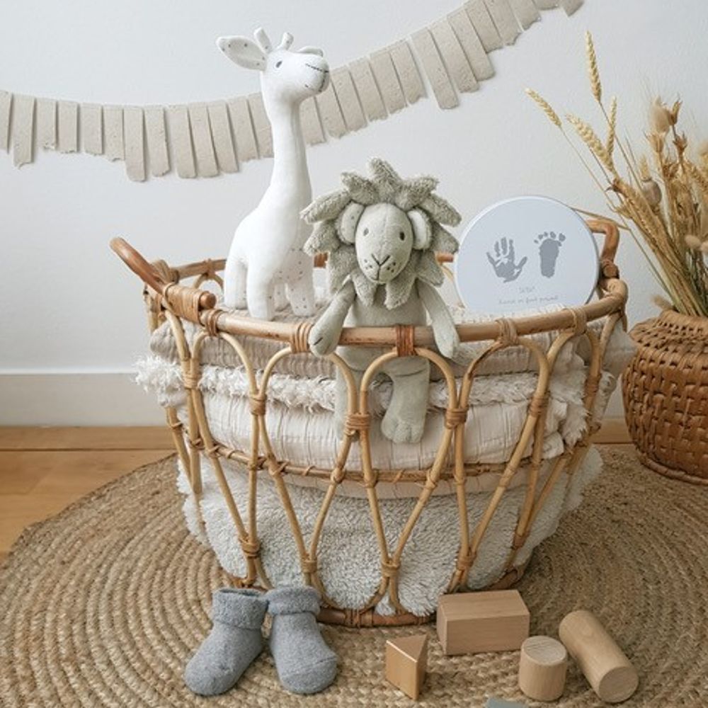 A selection of baby toys and accessories displayed in a wicker basket 