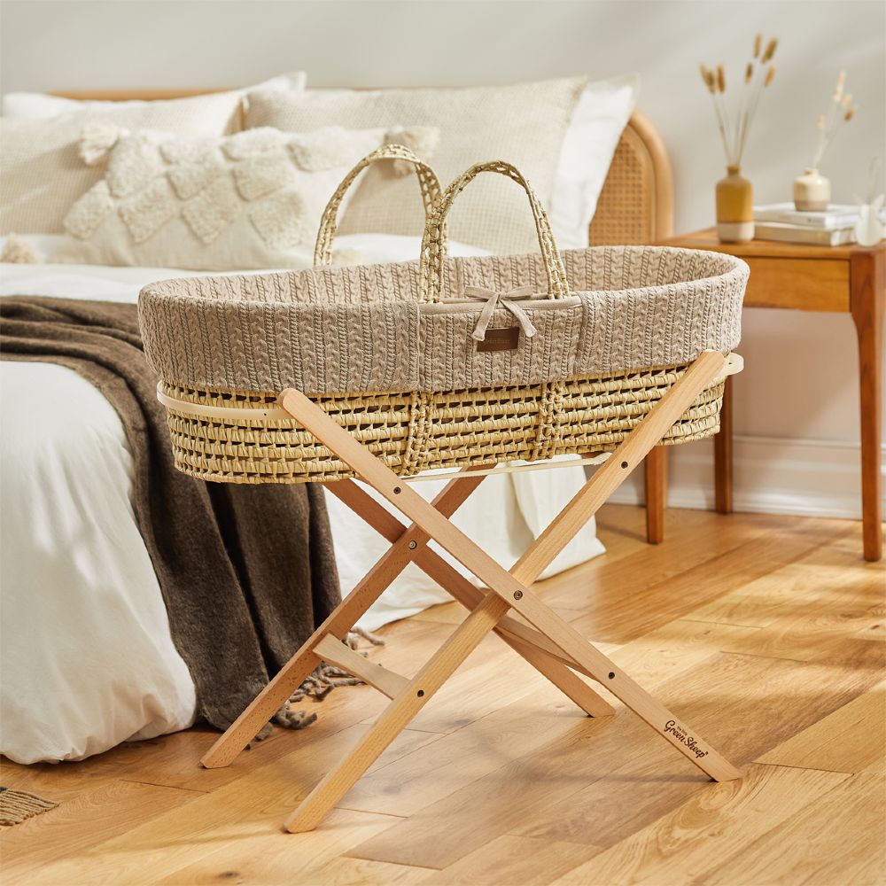 A Moses Basket on a stand in a bedroom 