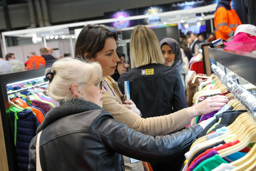 People looking at garments on a stand at the Printwear & Promotion LIVE! trade show 