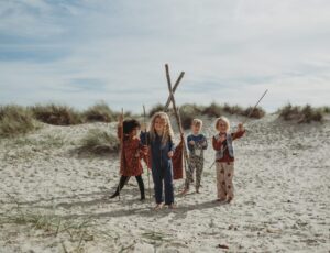 A group of young children stood on a beach