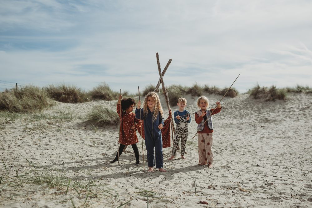 A group of young children stood on a beach