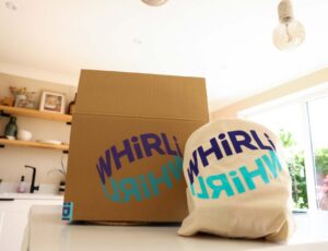 A cardboard box and bag on a worktop with the word Whirli on them