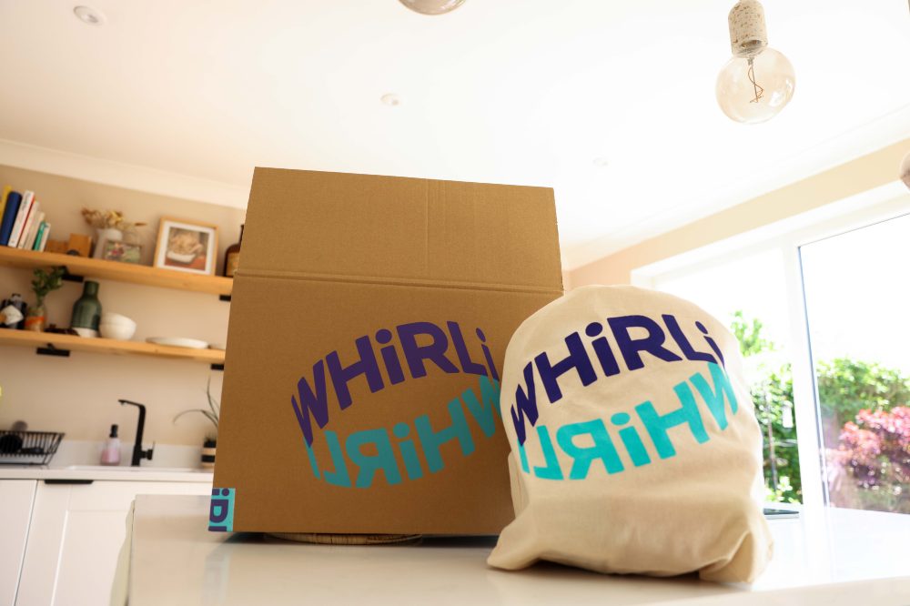 A cardboard box and bag on a worktop with the word Whirli on them