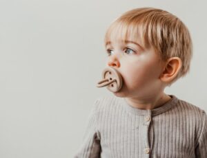 A young child with a dummy in its mouth