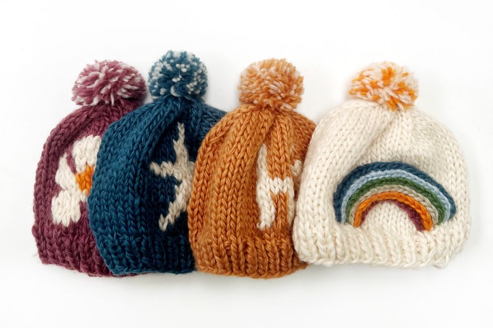 Four children's hand knitted bobble hats by Pebblechild