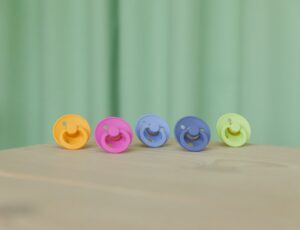 Brightly coloured BIBS pacifiers displayed in a row