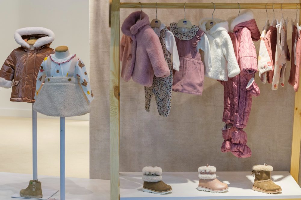 Children's clothes and shoes displayed on a stand at BKS + FIMI