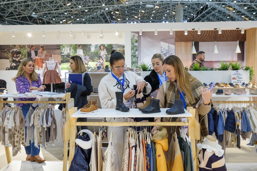 People looking at children's clothing on a stand at BKS + FIMI