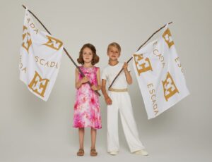 Two girls holding Escada flags wearing outfits from the new Escada Girls range