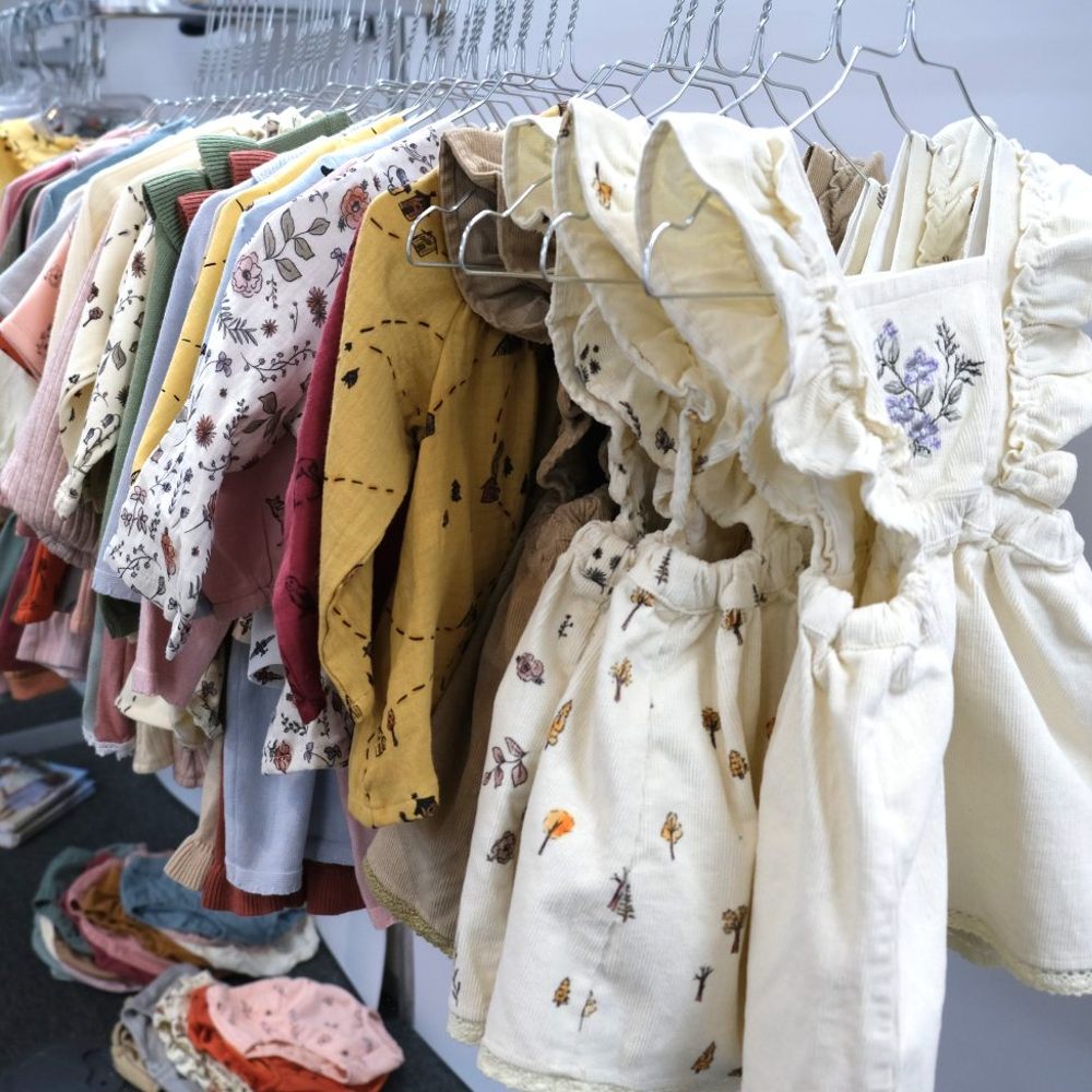 Children's clothes hung on a rail on metal clothes hangers