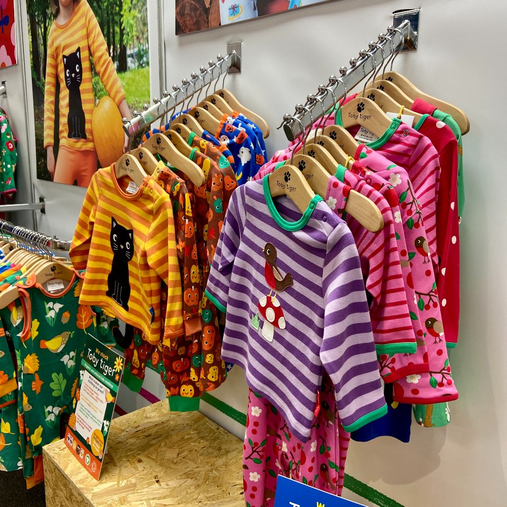 Brightly coloured children's clothes hung on a wall 