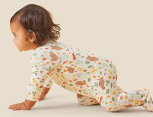 A baby crawling wearing a babygro from MORI's Gruffalo Collection