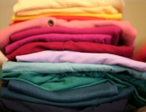 A pile of brightly coloured clothes stacked above each other