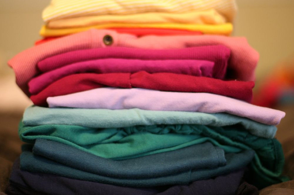 A pile of brightly coloured clothes stacked above each other