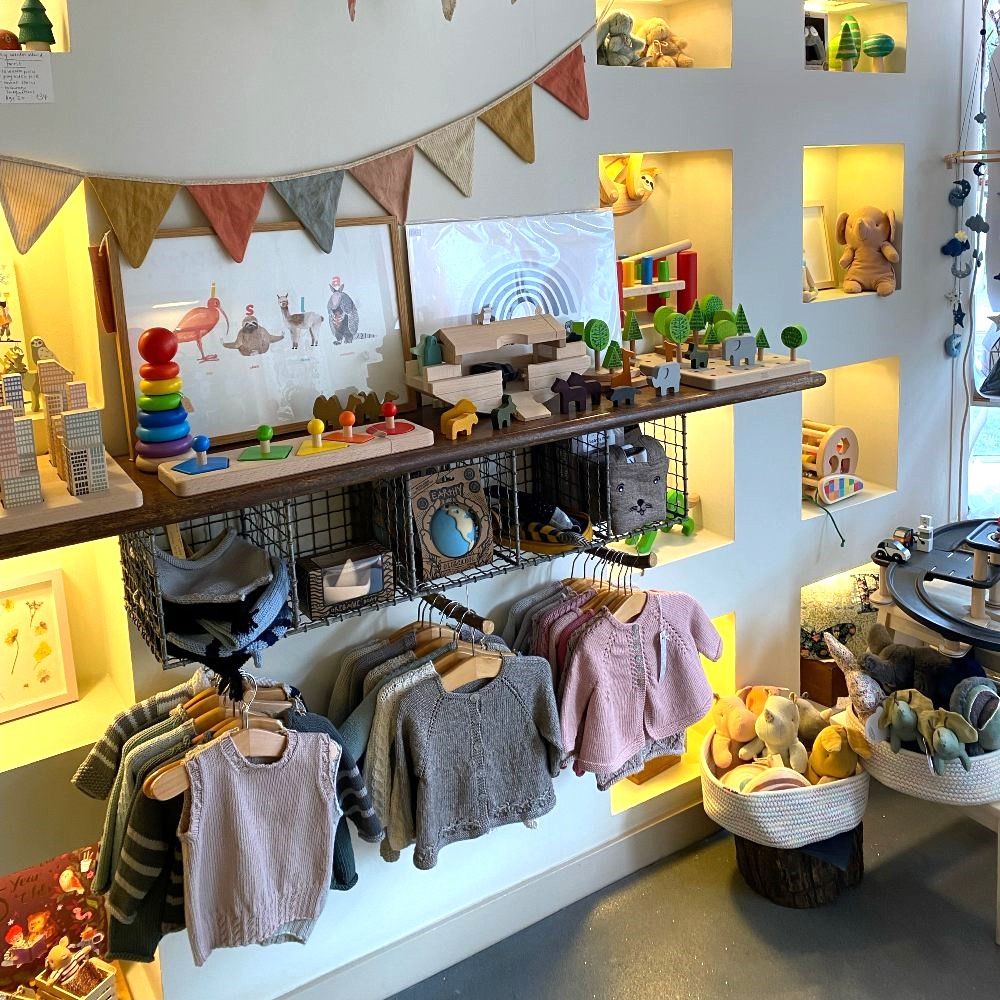 Children's clothes and toys displayed on a wall inside children's boutique Buttercup