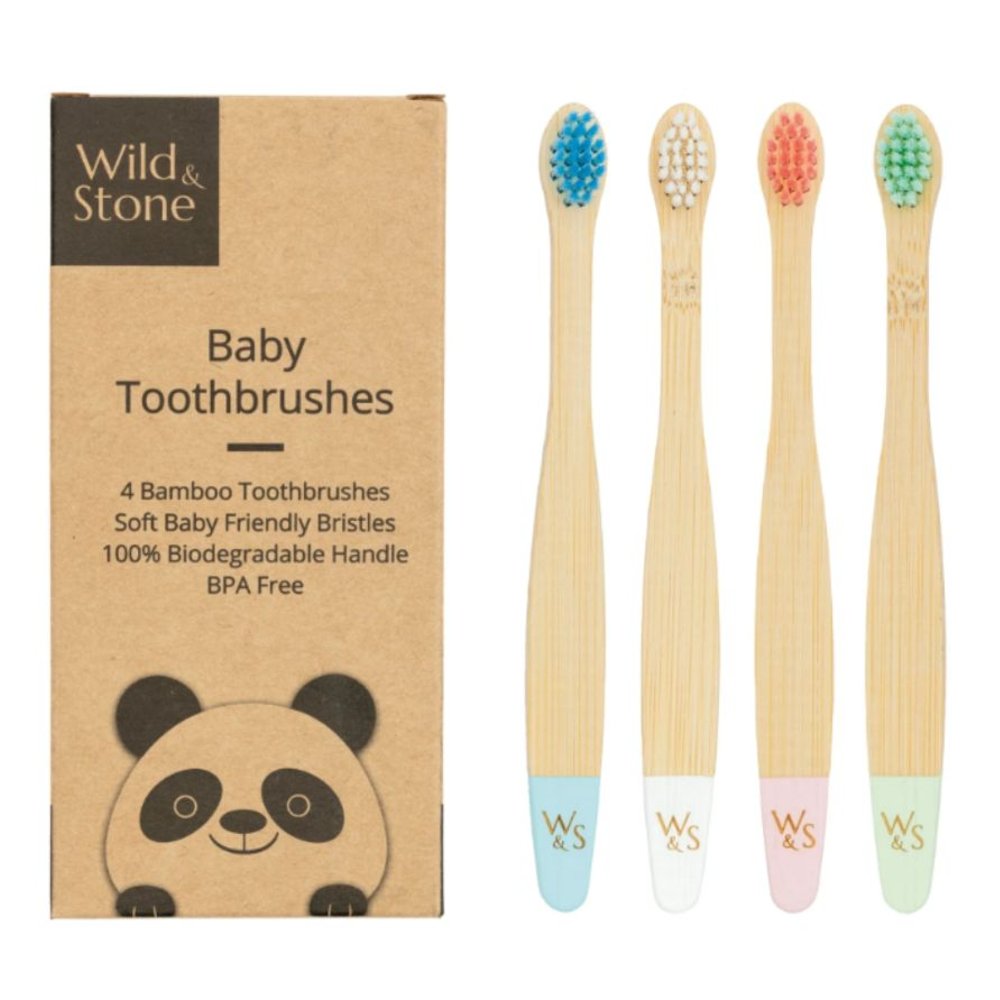 A set of four children's bamboo toothbrushes beside a box 