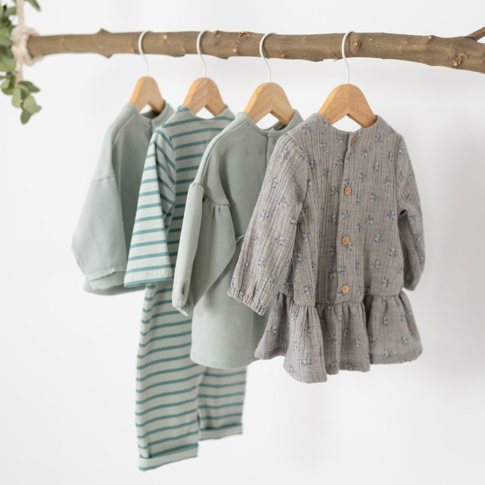 Children's clothes hung on a decorative branch 