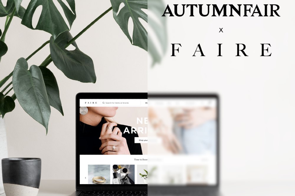 A laptop on a desk beside a plant with text saying Autumn Fair x Faire