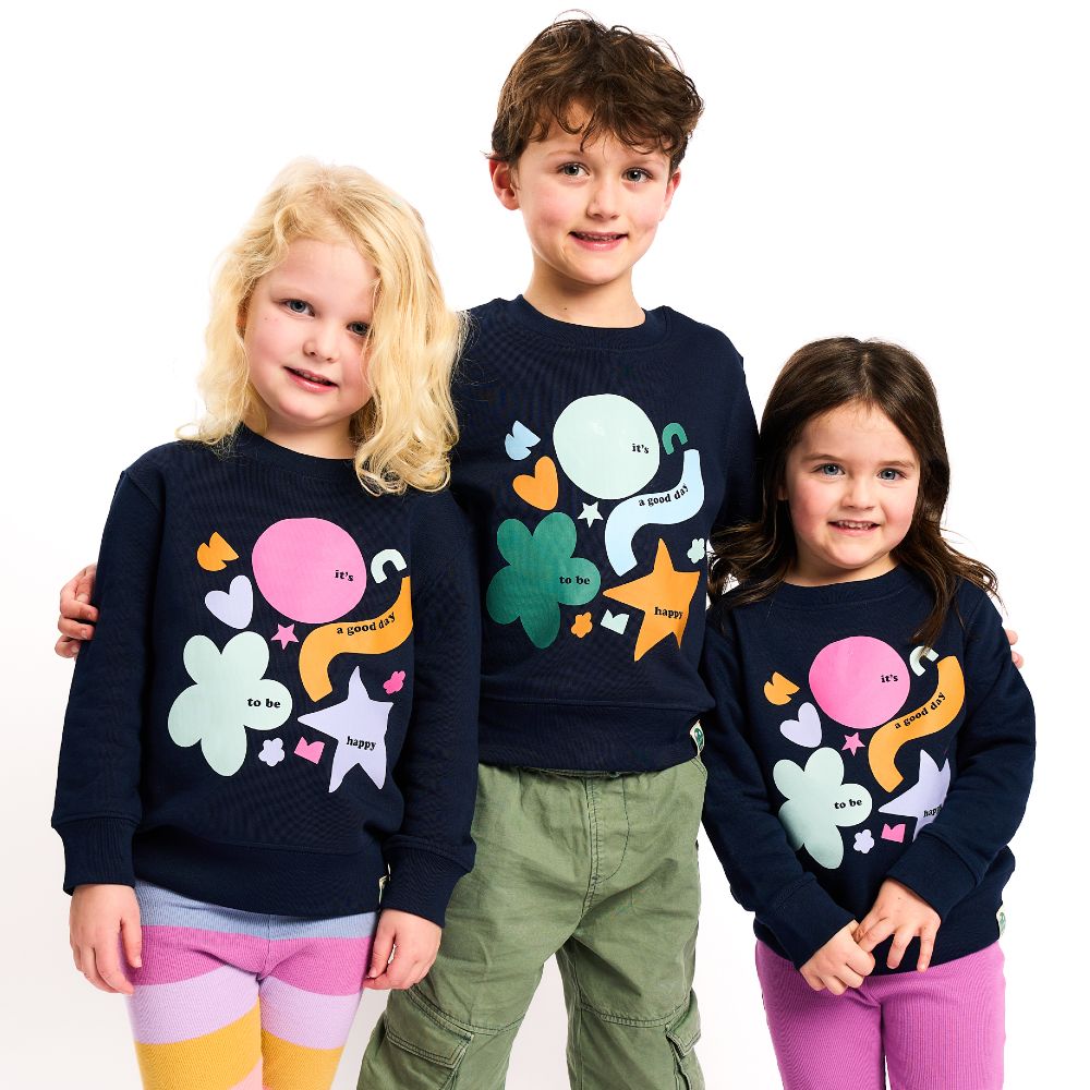 Three children stood together wearing matching printed sweatshirts by childrenswear brand Didee