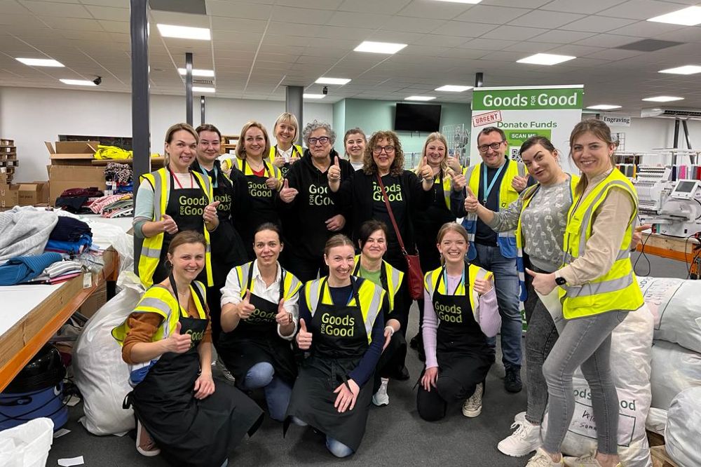 A group of people in a warehouse wearing Goods For Good tops 