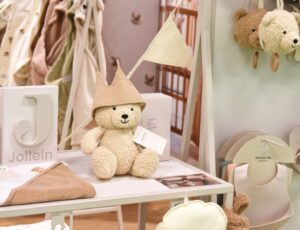Baby products and a teddy displayed on a stand at Harrogate International Nursery Fair