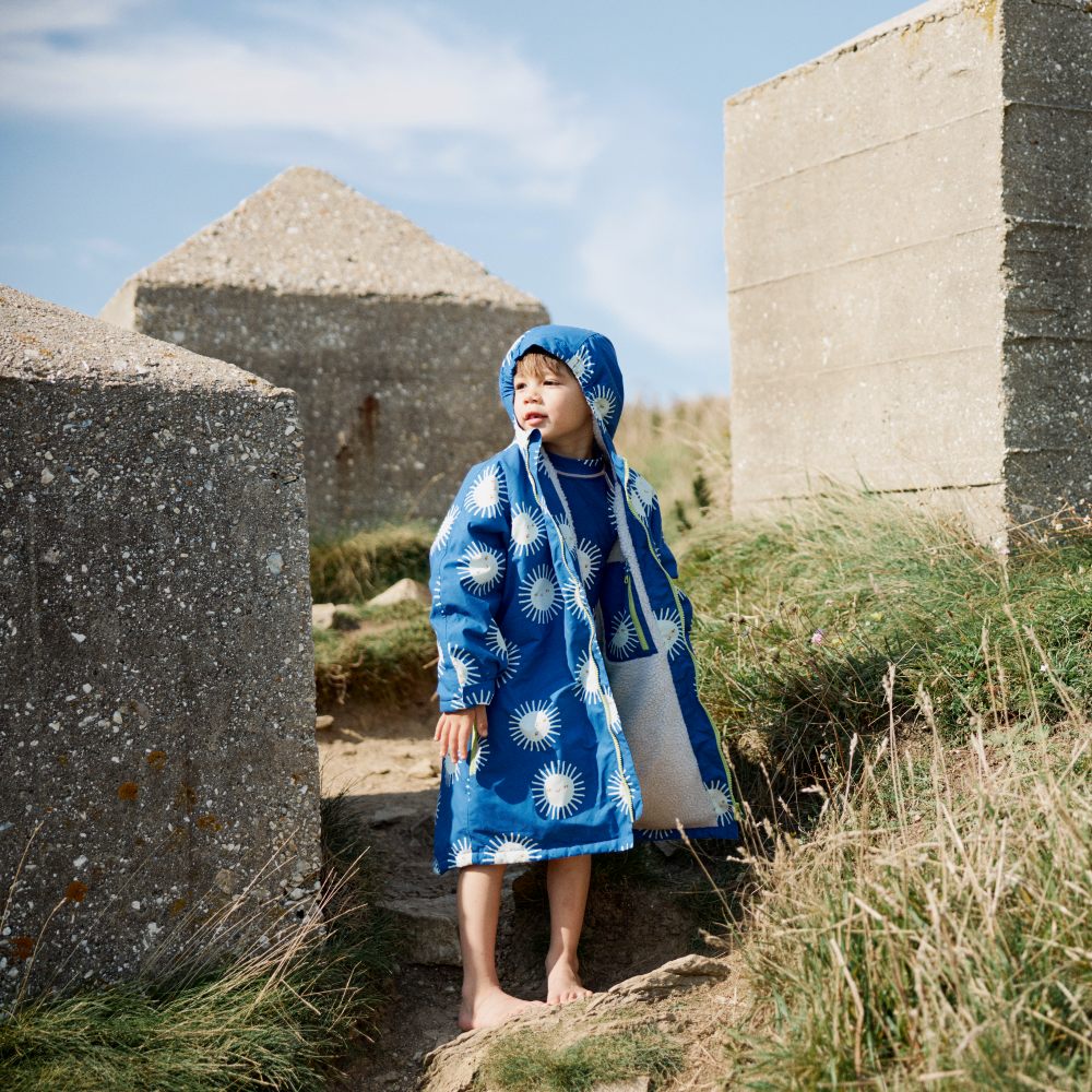 A child in a hooded blue robe stood outside 