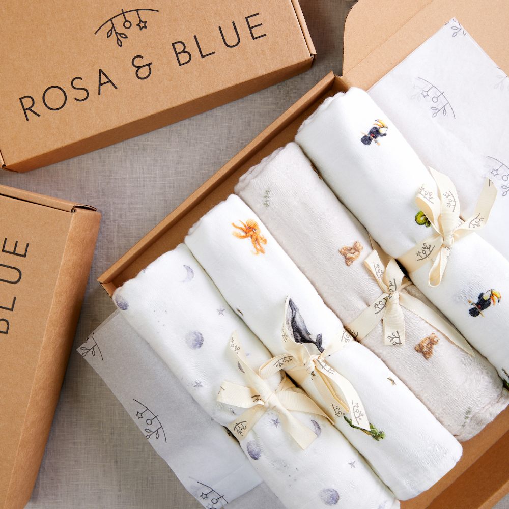 Rosa & Blue boxes containing rolled up childrenswear garments 