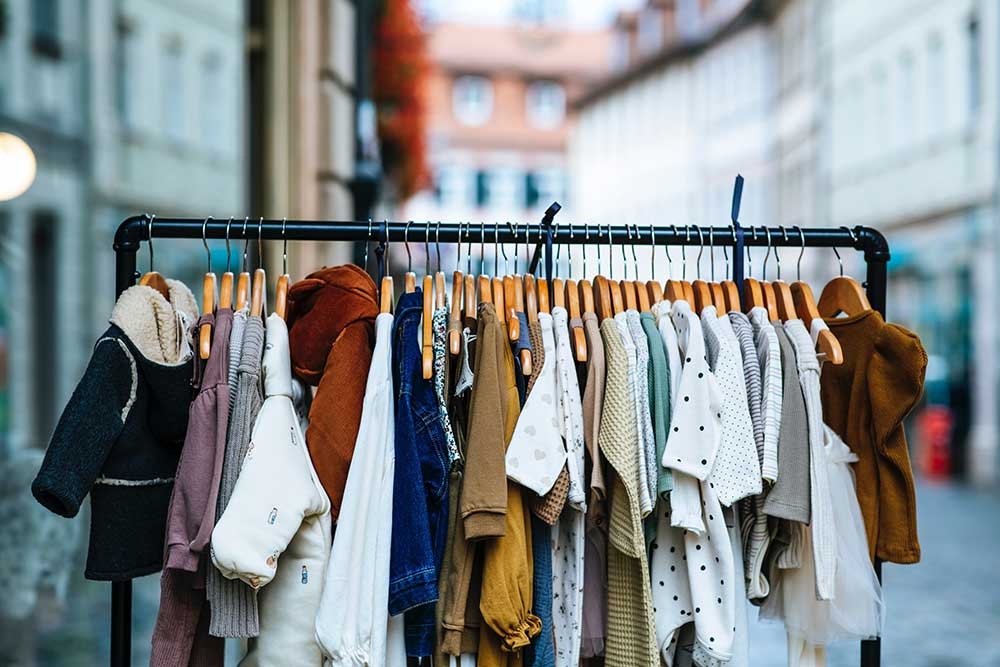 Children's clothes hanging on a clothes rail outside a store