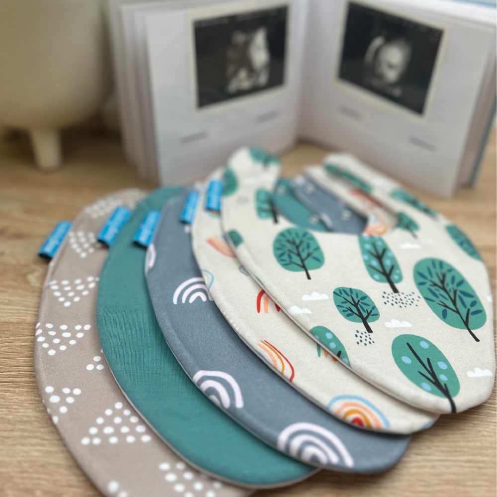 A selection of babies' patterned bibs displayed on a table 