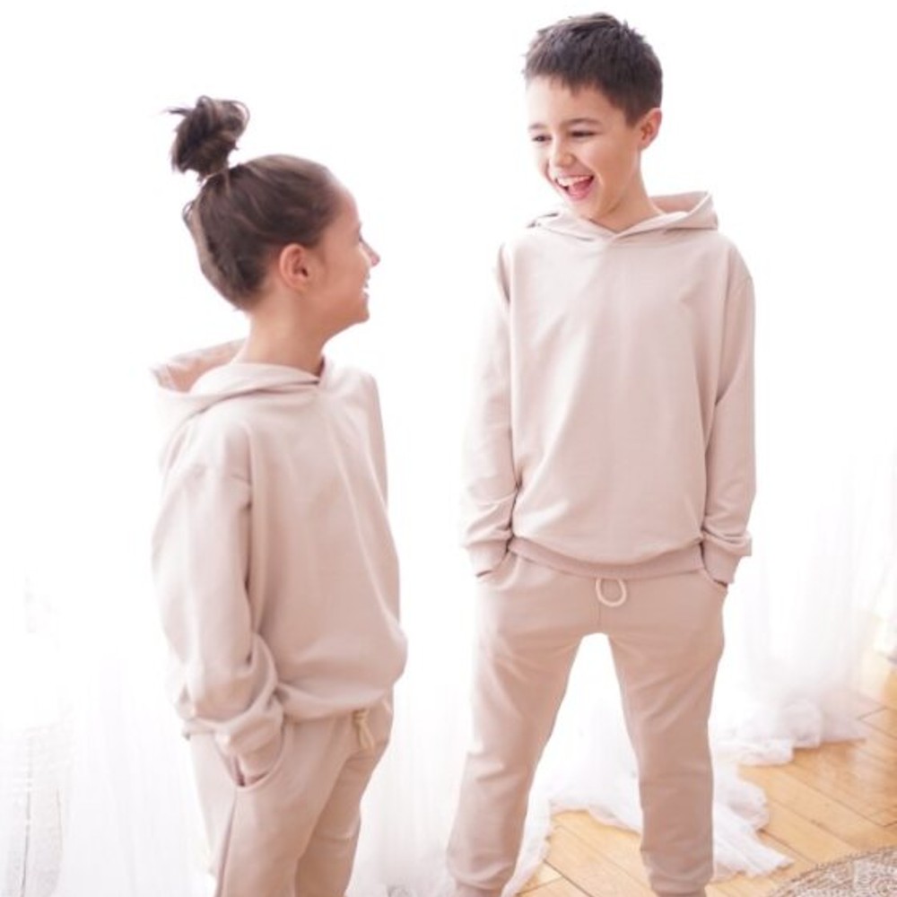 Two children in matching beige tracksuits 