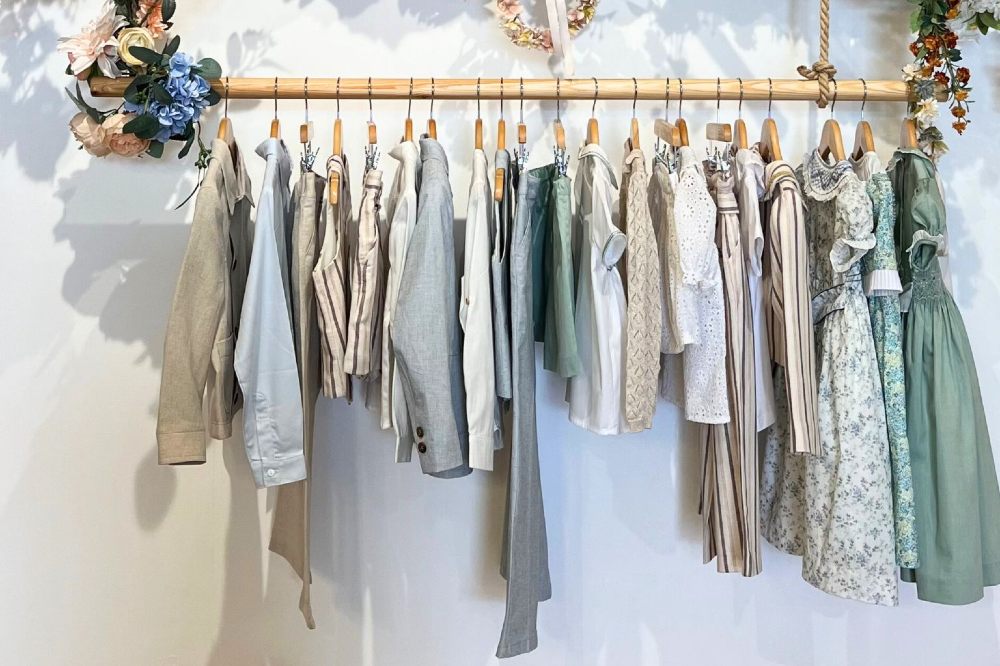 Children's clothes hung on a wooden rail in the Pepa London store