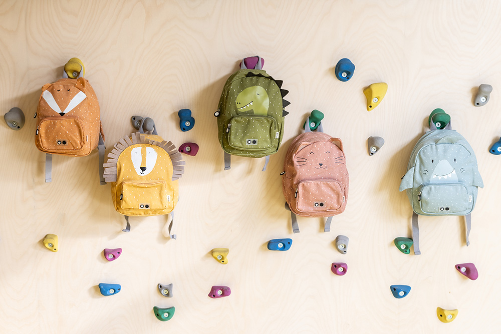 Five backpacks with animal designs hanging on a wall