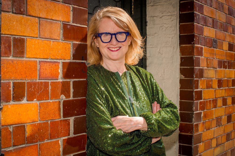 Head shot of Anna Pangbourne, chief executive of FTCT, stood in the doorway of a building wearing a green top