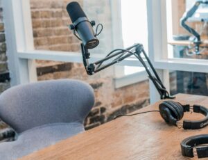 A desk set up for a podcast with a microphone and headphones