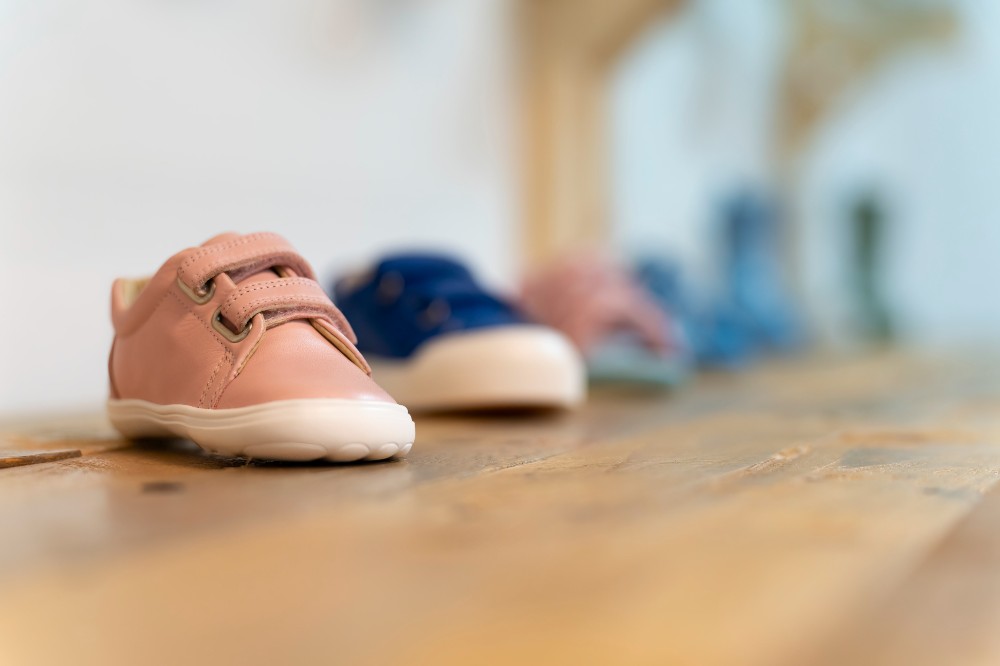 Children's shoes displayed on a wooden shelf 