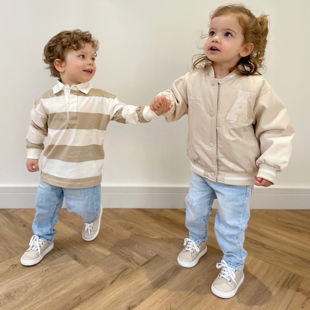Two young children reaching out to one another in a room 